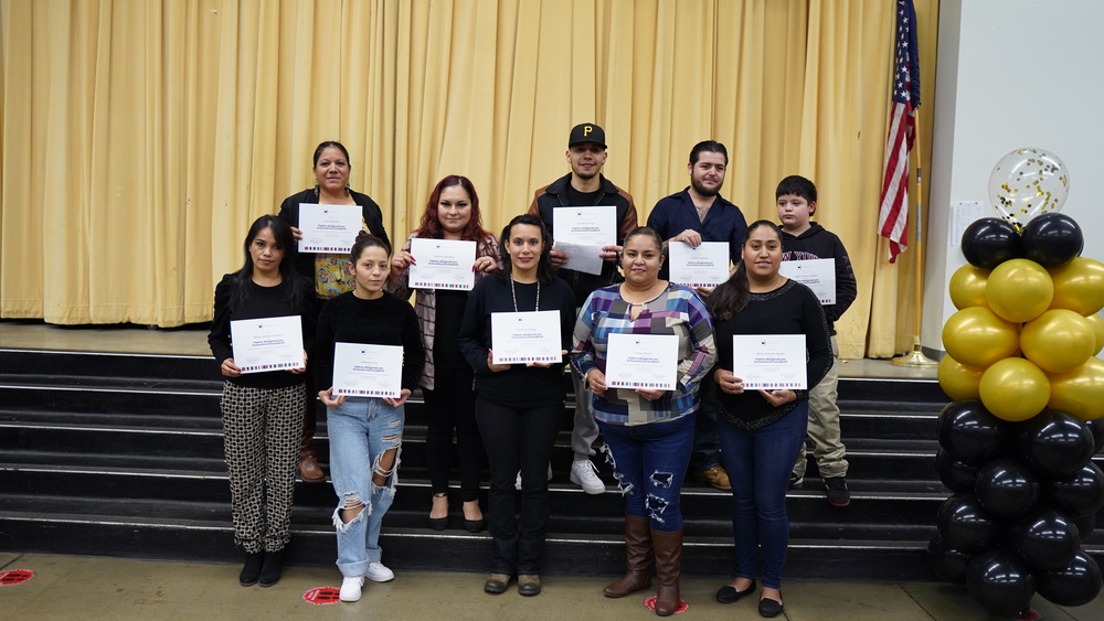 Parents holding graduation certificates