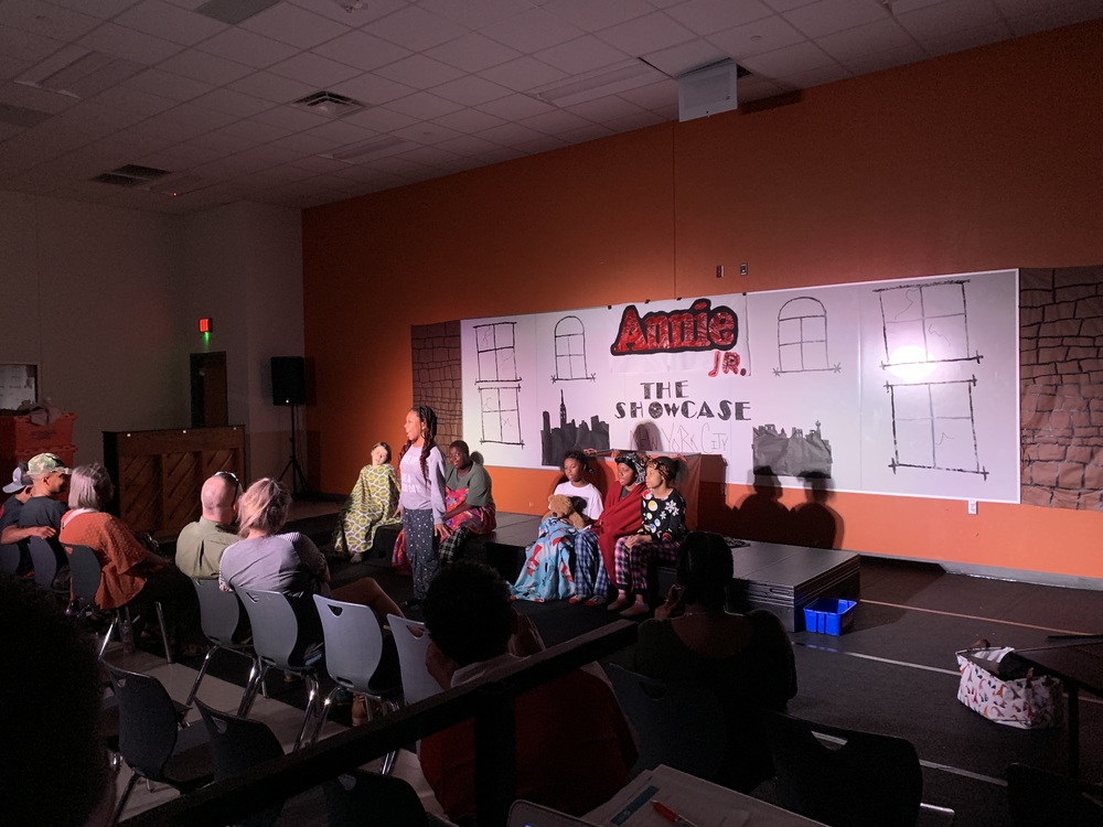 students perform a scene from annie jr