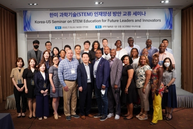 korea-us seminar on STEM eduation for future leader and innovators conference photo with group of leaders on stage under banner