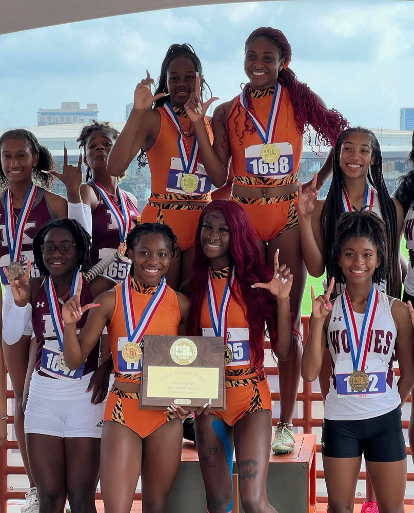 Track team poses with plaque