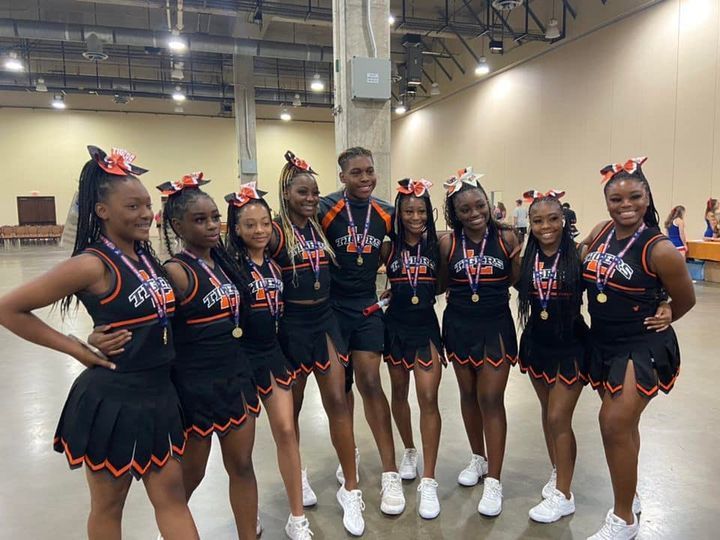 lancaster high school varsity cheerleaders in posing for picture in black cheer uniforms